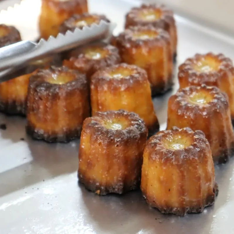 A tray of mini canel&eacute;s at the cat in the hat stall, dark caramelised crusts, lifted with serving tongs